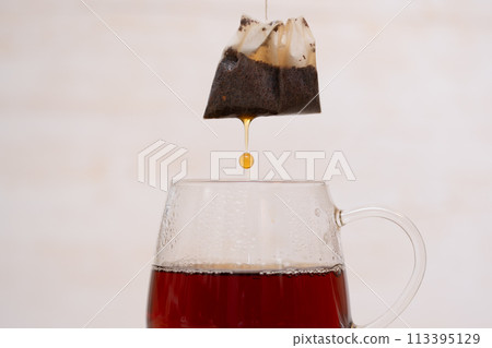 Tea drops falling from a tea bag 113395129