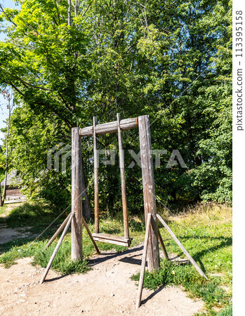 Old wooden swing in the Russian village on a sunny day Old wooden swing in the Russian village on a sunny day 113395158