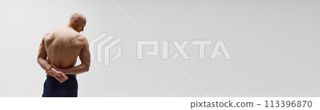 Banner. Rear view photo of young man posing demonstrate his muscular back against grey studio background with negative space. Banner. Rear view photo of young man posing demonstrate his muscular back against grey studio background with negative space. 113396870