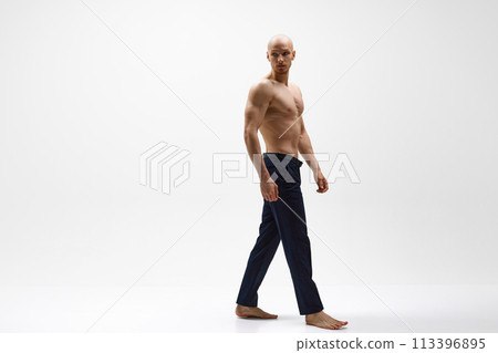 Full length portrait of young half-naked athletic man posing against grey studio background. Full length portrait of young half-naked athletic man posing against grey studio background. 113396895