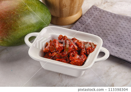 Spicy pickled raw green mango 113398304