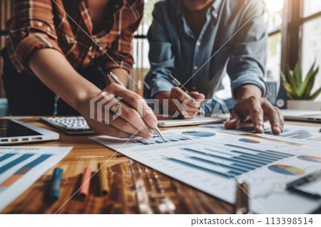 Professional team working together on financial statistics and graphs during a strategic business meeting Professional team working together on financial statistics and graphs during a strategic business meeting 113398514