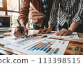 Professional team collaborating on business statistics and reports in close-up view 113398515