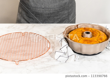 Cooling freshly baked pumpkin bundt cake on the kitchen counter. 113398766