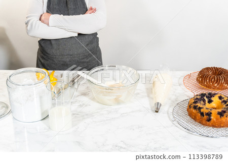 The final stage of this delightful baking journey involves artistically piping the silky cream cheese buttercream frosting atop the cooled bundt cakes, creating an irresistible treat. The final stage of this delightful baking journey involves artistically piping the silky cream cheese buttercream frosting atop the cooled bundt cakes, creating an irresistible treat. 113398789
