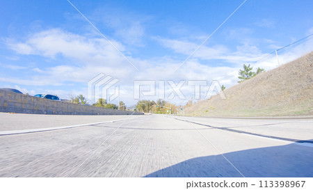 On a crisp winter day, a car cruises along the iconic Highway 101 near San Luis Obispo, California. The surrounding landscape is brownish and subdued, with rolling hills and patches of coastal On a crisp winter day, a car cruises along the iconic Highway 101 near San Luis Obispo, California. The surrounding landscape is brownish and subdued, with rolling hills and patches of coastal 113398967