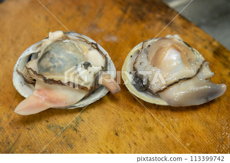 Surf clams washed up in Atsuma, Hokkaido. Raw surf clams with their shells removed are placed on a cutting board. Surf clams washed up in Atsuma, Hokkaido. Raw surf clams with their shells removed are placed on a cutting board. 113399742