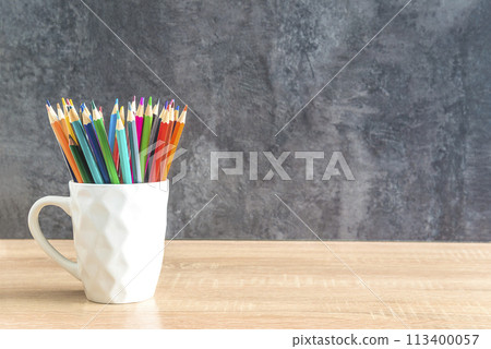 Heap of colorfull pencils on a wooden desk and gray background; copy space for your text 113400057