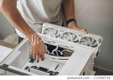 A detail-oriented computer technician, engaged in the delicate process of hardware assembly 113400758