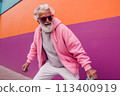 Smiling happy cool gray haired bearded hipster old senior man skater with skateboard in hand on pink background. Older people freedom spirit concept 113400919