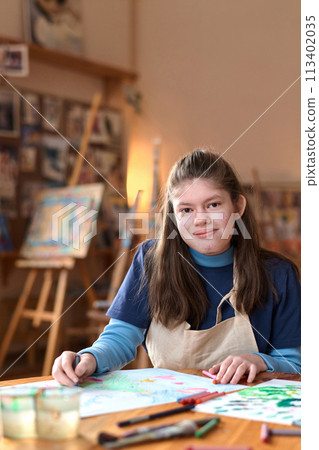 Vertical portrait of smiling teen girl with Williams syndrome looking at camera in art studio Vertical portrait of smiling teen girl with Williams syndrome looking at camera in art studio 113402035