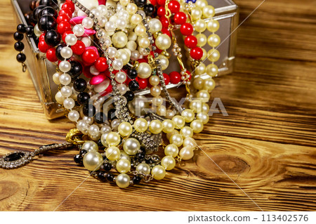 Jewelry box full of jewelry and accessories on wooden background 113402576