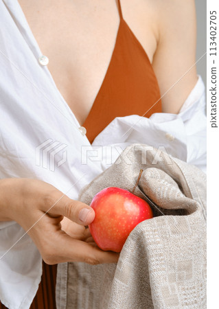 Unrecognizable woman wiping an apple with a towel Unrecognizable woman wiping an apple with a towel 113402705