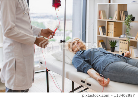 General practitioner checking tubes which blood flows of female. 113402987