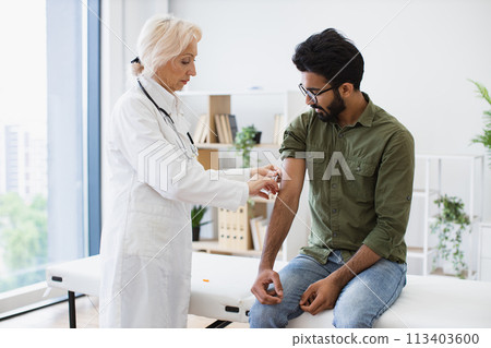 General practitioner giving injection to boost immunity for young patient. General practitioner giving injection to boost immunity for young patient. 113403600