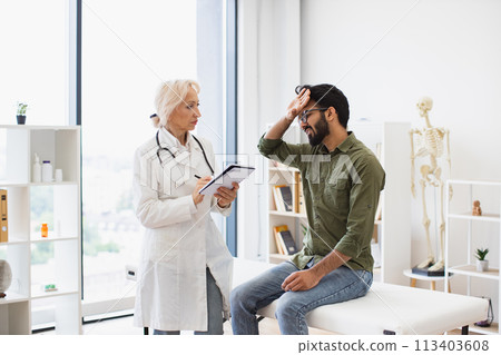 Elder physician giving recommendations and writing prescription. 113403608