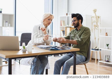 Mature elder physician giving recommendations regarding treatment. 113403669