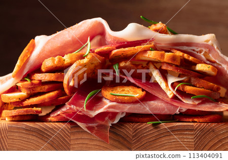Prosciutto and bruschetta with rosemary. Macro shot. 113404091