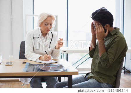 Man with headache listening to recommendations regarding medical history. Man with headache listening to recommendations regarding medical history. 113404244