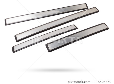 A four of black plastic decorative door sills in an automobile parsing for sale or repair in a workshop on a white isolated background in a photo studio. A four of black plastic decorative door sills in an automobile parsing for sale or repair in a workshop on a white isolated background in a photo studio. 113404460