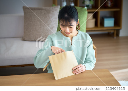 便衣女青年在家檢查包裹 便衣女青年在家檢查包裹 113404615