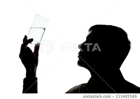Young man drinks, checks the quality of soda water - silhouette 113405589