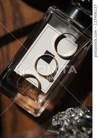 Three beautiful golden rings on elegant perfumes. In the middle ring with diamond  113406137