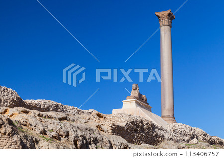 Alexandria, Egypt. Ancient sphinx with Pompeys Pillar 113406757