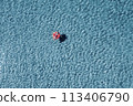 A child swims on a red inflatable circle. The concept of beach holidays and relaxation. Aerial. . High quality photo 113406790