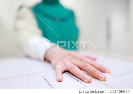 Young man having x-ray shot of broken hand in x-ray room in modern clinic. Patient wearing in protect lead apron 113406934
