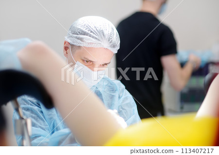 Gynecologist operation patient in gynecological chair. Doctor performs invasive medical procedure in modern hospital. Diagnosis and treatment of cervical cancer. Surgical removal of uterine cyst 113407217