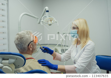Male smiling during her dental treatment at dentist. 113407635
