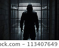 A hooded man in a dark prison cell. AI created.  113407649