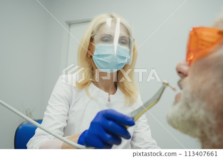Male smiling during her dental treatment at dentist. Male smiling during her dental treatment at dentist. 113407661