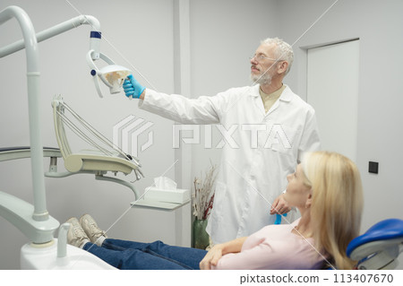 Woman smiling during her dental treatment at dentist. 113407670