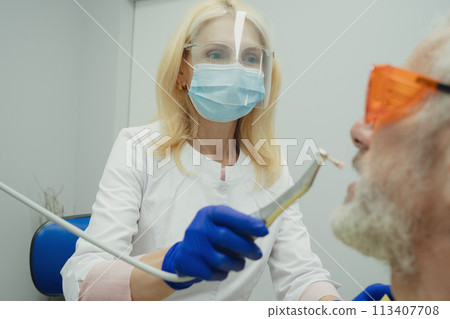 Male smiling during her dental treatment at dentist. 113407708