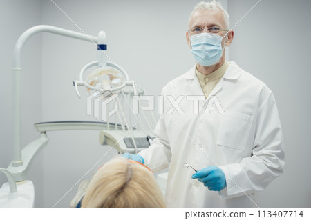 Woman smiling during her dental treatment at dentist. Woman smiling during her dental treatment at dentist. 113407714