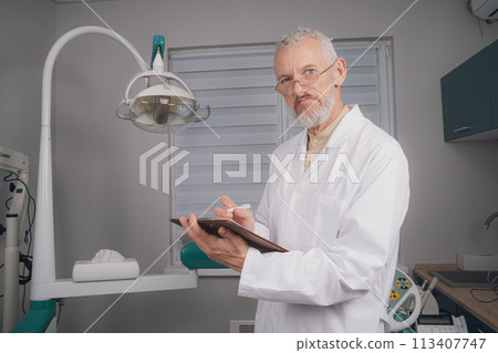 Portrait of attractive handsome dentist with haircut, white lab coat. 113407747