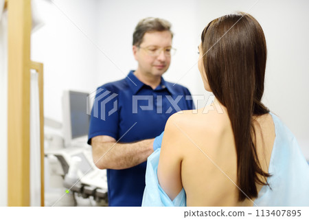 Doctor mammologist examines woman breasts. Correcting the shape of the breast - lift, reduction, reconstruction, augmentation. Problems of lactation. Breast cancer. 113407895