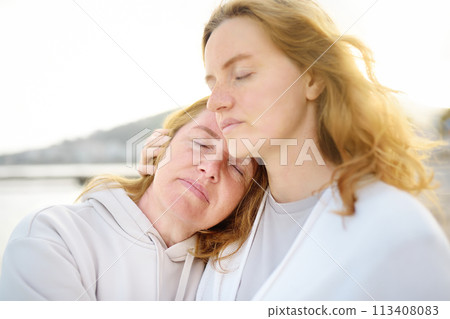 Cute woman tenderly hugs her mature mother on Mother's Day Cute woman tenderly hugs her mature mother on Mother's Day 113408083