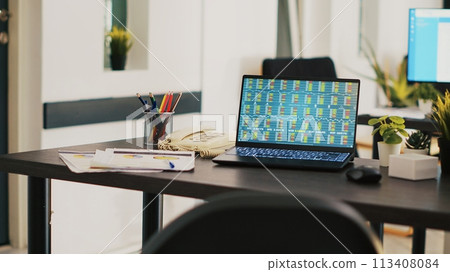 Laptop in company office shows stock exchange values changing in real time, panning shot. Paperwork on desk next to notebook showing forex trading indexes and pie charts graphs Laptop in company office shows stock exchange values changing in real time, panning shot. Paperwork on desk next to notebook showing forex trading indexes and pie charts graphs 113408084