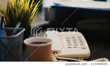 Cup of coffee on office desk next to paperwork containing business financial information income statements, close up shot. Company invoice documents and hot beverage in accounting workspace Cup of coffee on office desk next to paperwork containing business financial information income statements, close up shot. Company invoice documents and hot beverage in accounting workspace 113408099