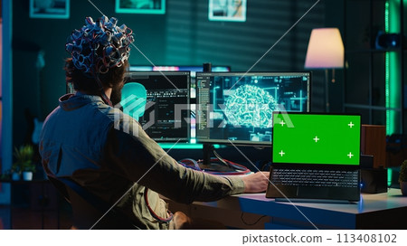IT admin coding and using EEG headset to upload brain into green screen laptop, gaining immortality. Neuroscientist engineering transhumanism experiment on chroma key device, camera A IT admin coding and using EEG headset to upload brain into green screen laptop, gaining immortality. Neuroscientist engineering transhumanism experiment on chroma key device, camera A 113408102