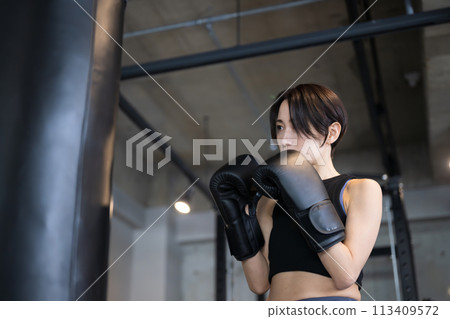 一個酷帥的女人在健身房打拳擊和拳擊運動的前視特寫 113409572