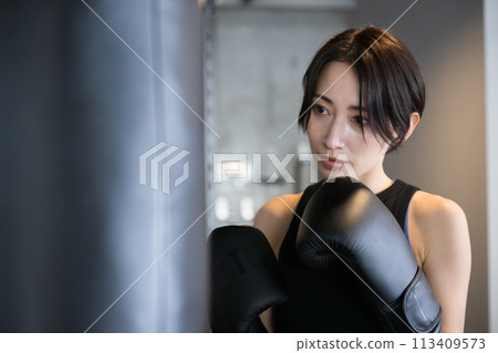 一個酷帥的女人在健身房打拳擊和拳擊運動的前視特寫 113409573