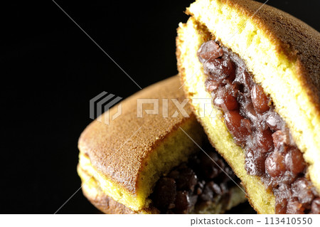 Cut dorayaki photographed against a black background 113410550
