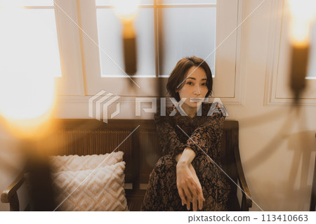 中年婦女坐在房間的沙發上 中年婦女坐在房間的沙發上 113410663