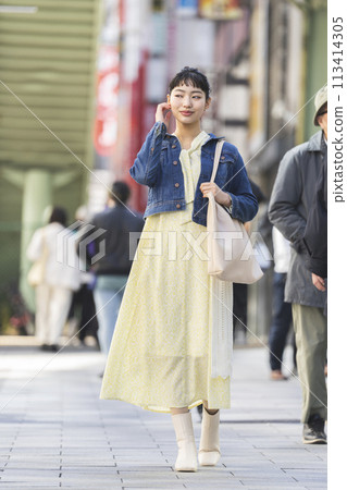 A young lady walking in the city 113414305