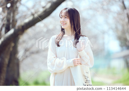 一個女人沿著櫻花樹河床散步 一個女人沿著櫻花樹河床散步 113414644