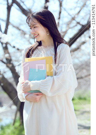 一個女人沿著櫻花樹河床散步 一個女人沿著櫻花樹河床散步 113414761